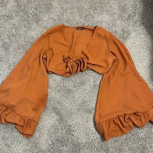 cropped burnt orange top with tie around front and float sleeve